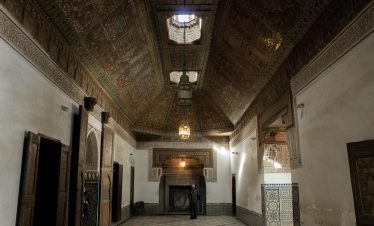 Explore a beautifully ornate interior room featuring traditional Moroccan ceilings and architecture.