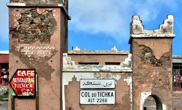 Historic Col du Tichka sign and structure on a sunny day in Morocco.