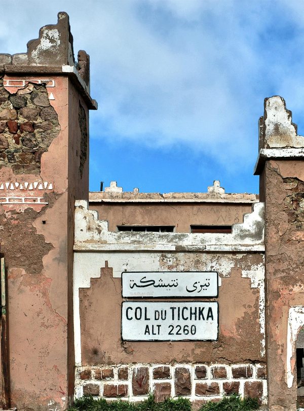 Historic Col du Tichka sign and structure on a sunny day in Morocco.